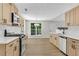 Well-lit kitchen with stainless steel appliances, light-colored cabinets, and hardwood flooring at 8592 Hidden Creek Cir, Snellville, GA 30039