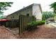 View of the backyard featuring a wooden fence, the building's siding, and some small bushes at 122 Summer Pl, Norcross, GA 30071