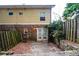 View of the backyard featuring a brick foundation, wooden fence, and double doors to the building at 122 Summer Pl, Norcross, GA 30071