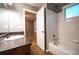 Well-lit bathroom featuring a vanity with granite countertop, a shower-tub combo with white tiles, and an open doorway at 122 Summer Pl, Norcross, GA 30071