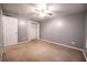 Bedroom with grey walls, tan carpet, and a closet with open doors at 122 Summer Pl, Norcross, GA 30071