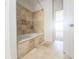 Bathroom featuring a soaking tub with tiled surround and tile flooring at 200 Renaissance Ne Pkwy # 310, Atlanta, GA 30308