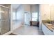 Bright bathroom with a soaking tub, glass-enclosed shower, double vanity, and neutral tile flooring at 2092 Wood Nw Trl, Atlanta, GA 30318