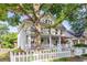 Attractive two-story home with a welcoming front porch, complemented by a white picket fence and lush trees at 2092 Wood Nw Trl, Atlanta, GA 30318