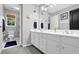 Clean bathroom featuring double sinks, white cabinets, a window, and framed wall art at 285 Finsbury Park Ct, Suwanee, GA 30024