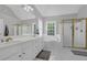 Bright bathroom featuring dual sinks, a soaking tub, and a separate shower with a glass door at 285 Finsbury Park Ct, Suwanee, GA 30024