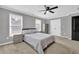 Comfortable bedroom with large windows providing ample natural light and a ceiling fan at 285 Finsbury Park Ct, Suwanee, GA 30024