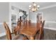 Elegant dining room with wood table, chandelier, and open view to the foyer, perfect for gatherings and meals at 285 Finsbury Park Ct, Suwanee, GA 30024