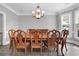 Formal dining room with a large wooden table, elegant chandelier, and bright natural light, ideal for entertaining at 285 Finsbury Park Ct, Suwanee, GA 30024