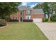 Charming two-story brick home with well-maintained lawn and mature trees, showcasing classic curb appeal at 285 Finsbury Park Ct, Suwanee, GA 30024