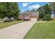 Beautiful brick home with a long driveway, lush green lawn, and mature trees, offering a serene setting at 285 Finsbury Park Ct, Suwanee, GA 30024