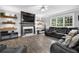 Spacious living room boasts a fireplace, floating shelves, and a comfortable black leather sectional at 285 Finsbury Park Ct, Suwanee, GA 30024