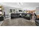 Open concept living room featuring a large black sectional and views into the kitchen area at 285 Finsbury Park Ct, Suwanee, GA 30024
