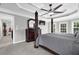 Spacious main bedroom features a tray ceiling, a ceiling fan and a large window letting in natural light at 285 Finsbury Park Ct, Suwanee, GA 30024