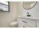 Elegant half-bathroom featuring a modern vanity with black hardware and a stylish round mirror at 2931 Randolph Ct, Conyers, GA 30012