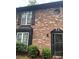 Charming brick townhome exterior featuring detailed architectural accents and lush, manicured landscaping at 658 Garden Walk Dr, Stone Mountain, GA 30083