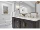 Renovated bathroom with double vanity, black cabinets, and gold hardware provides modern elegance and convenience at 696 Kenilworth Cir, Stone Mountain, GA 30083