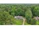 A cozy home features a large lot and is surrounded by a vibrant green forest in an aerial shot at 105 Laney Ct, Mcdonough, GA 30252