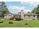 Backyard showcasing lawn, garden area, home's rear elevation, and a deck at 105 Laney Ct, Mcdonough, GA 30252