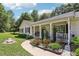 Inviting front porch with white railings, colorful flowers, and well-manicured plants along the walkway at 105 Laney Ct, Mcdonough, GA 30252