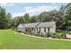 Charming single-story home with well-manicured lawn, black shutters, and inviting front porch with colorful landscaping at 105 Laney Ct, Mcdonough, GA 30252