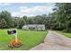 Inviting home exterior with a long driveway, a manicured lawn, and vibrant flowers around the mailbox at 105 Laney Ct, Mcdonough, GA 30252