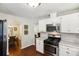 Open kitchen with white cabinets, stainless steel appliances, and access to the dining room at 105 Laney Ct, Mcdonough, GA 30252