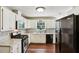 Well-lit kitchen features updated appliances, white cabinets, tile backsplash, and hardwood floors at 105 Laney Ct, Mcdonough, GA 30252