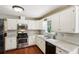 Efficient kitchen features white cabinets, modern stainless steel appliances, and tiled backsplash at 105 Laney Ct, Mcdonough, GA 30252