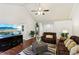 Bright living room with vaulted ceiling, hardwood floors, ceiling fan, and large TV for entertainment at 105 Laney Ct, Mcdonough, GA 30252