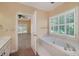 Bright bathroom with a soaking tub, white shutters, and view to the bedroom at 170 Glen Eagle Way, Mcdonough, GA 30253