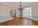 Elegant dining room with hardwood floors, chandelier, and large windows providing natural light at 170 Glen Eagle Way, Mcdonough, GA 30253