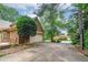 Long driveway leading to a two-car garage surrounded by mature trees and lush landscaping at 170 Glen Eagle Way, Mcdonough, GA 30253