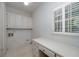 Laundry room with white cabinets, utility sink, and ample countertop space at 170 Glen Eagle Way, Mcdonough, GA 30253