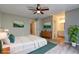 This staged bedroom features hardwood floors, a ceiling fan, and attached bathroom at 129 Lester Nw Rd, Lawrenceville, GA 30044