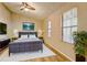 Nicely staged primary bedroom with ceiling fan, modern decor and bright windows at 129 Lester Nw Rd, Lawrenceville, GA 30044
