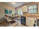 A staged kitchen features stainless steel dishwasher, white cabinets, and a dining table with chairs at 129 Lester Nw Rd, Lawrenceville, GA 30044