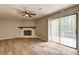 Bright living room with hardwood floors, fireplace, ceiling fan, and sliding doors to outdoor deck at 129 Lester Nw Rd, Lawrenceville, GA 30044
