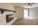 Living room featuring stone fireplace, hardwood floors, ceiling fan, and sliding doors to outdoor deck at 129 Lester Nw Rd, Lawrenceville, GA 30044