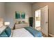 Nicely staged primary bedroom with a blue comforter, accent pillows, and a connecting door at 129 Lester Nw Rd, Lawrenceville, GA 30044