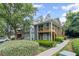 Exterior view of a condominium with wooden balconies and well-manicured landscaping, with a car parked in the background at 202 Berkeley Woods Dr, Duluth, GA 30096