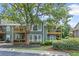Inviting condominium with a wood balcony, surrounded by lush landscaping and mature trees at 202 Berkeley Woods Dr, Duluth, GA 30096