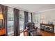 Sunlit sitting area features hardwood floors, a leather chair, and windows with blinds and curtains at 202 Berkeley Woods Dr, Duluth, GA 30096