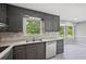 This is a kitchen with painted gray cabinets and stainless steel appliances, and a large double sink at 2676 Abington Dr, Snellville, GA 30078