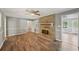 Open-concept living room with hardwood floors, a brick fireplace, and neutral decor at 2676 Abington Dr, Snellville, GA 30078