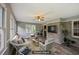 Staged living room with brick accent wall, neutral colored walls, large windows, hardwood floors and a ceiling fan at 2676 Abington Dr, Snellville, GA 30078