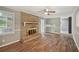 Cozy living room featuring a brick fireplace, hardwood floors, and large windows at 2676 Abington Dr, Snellville, GA 30078