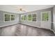 Living room with hardwood floors, three large windows, neutral colored walls, and a view to the backyard at 2676 Abington Dr, Snellville, GA 30078