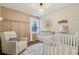Charming Bedroom with a comfortable chair, changing table, and white crib bathed in natural light at 3351 Landrum Se Dr, Smyrna, GA 30082