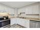 Cozy kitchen featuring white cabinetry, stainless steel appliances, and wood-look vinyl flooring at 3351 Landrum Se Dr, Smyrna, GA 30082